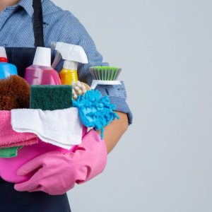 young-girl-is-holding-cleaning-product-gloves-rags-basin-white-wall